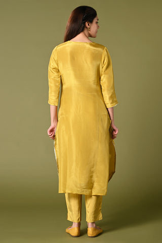 Pale mustard yellow shimmer fabric kurti set with floral printed organza dupatta, gotta patti work and straight pants.
•	Plain top with gotta patti work.
•	Round neck & 3/4 sleeves.
•	Single sided elastic and comfortable straight pants.
•	Floral printed organza dupatta with tassels.
•	Shimmer fabric material
•	The shimmer fabric with prints will give you a perfect occasional look.
