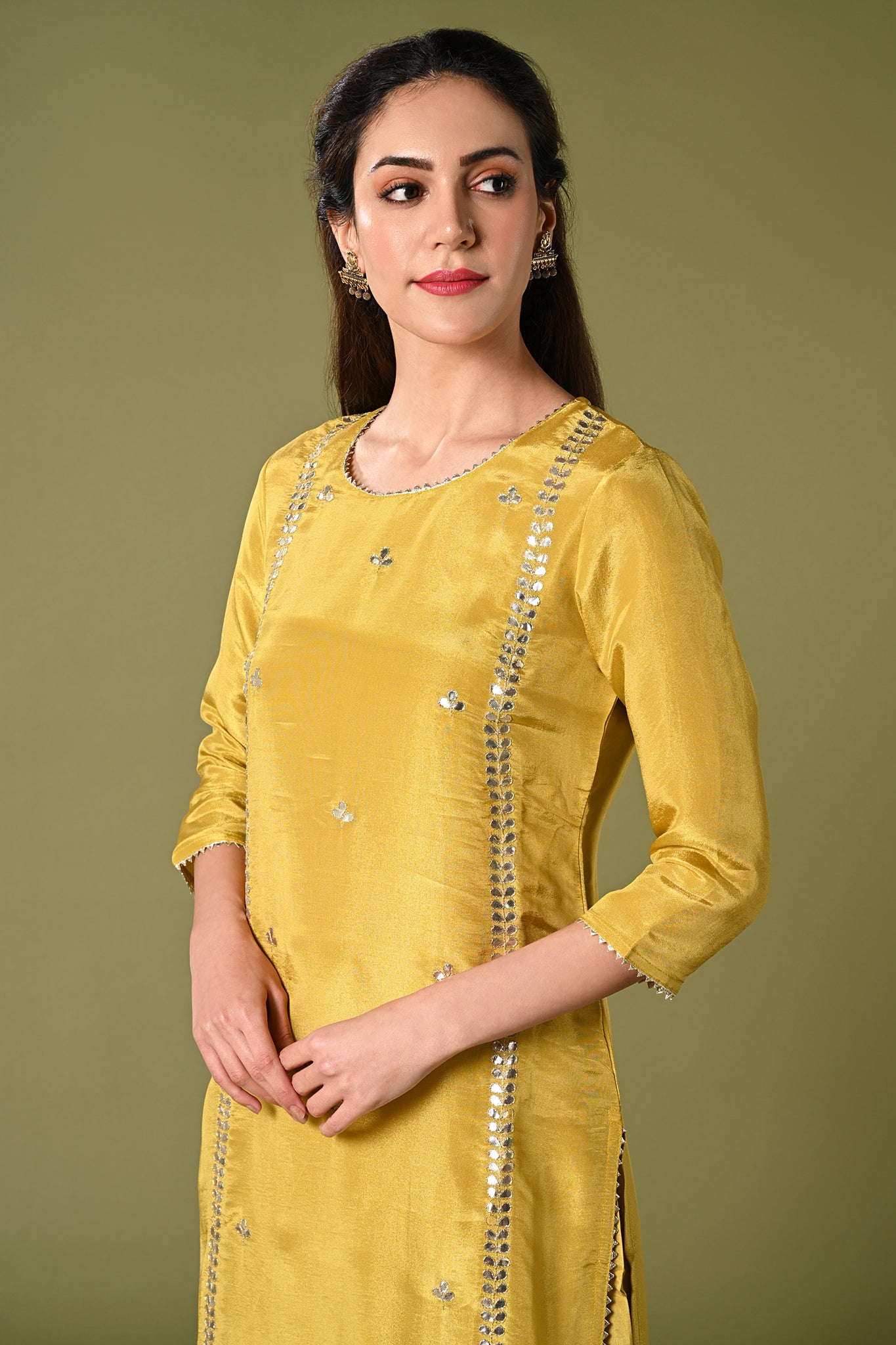 Pale mustard yellow shimmer fabric kurti set with floral printed organza dupatta, gotta patti work and straight pants.
•	Plain top with gotta patti work.
•	Round neck & 3/4 sleeves.
•	Single sided elastic and comfortable straight pants.
•	Floral printed organza dupatta with tassels.
•	Shimmer fabric material
•	The shimmer fabric with prints will give you a perfect occasional look.
